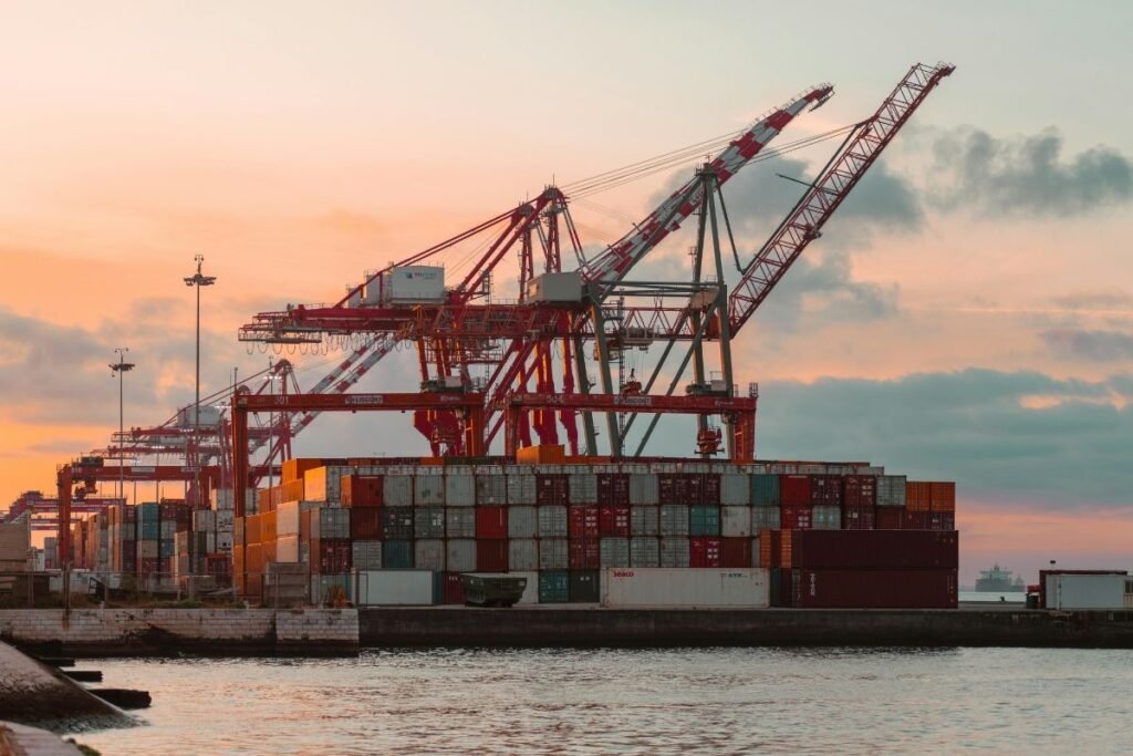 Container port with cranes at sunset